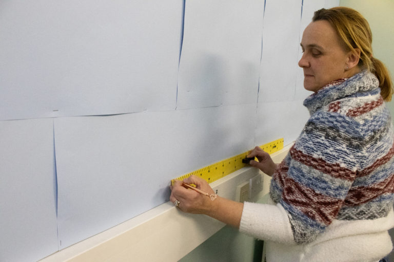 Learner measures area on wall for display