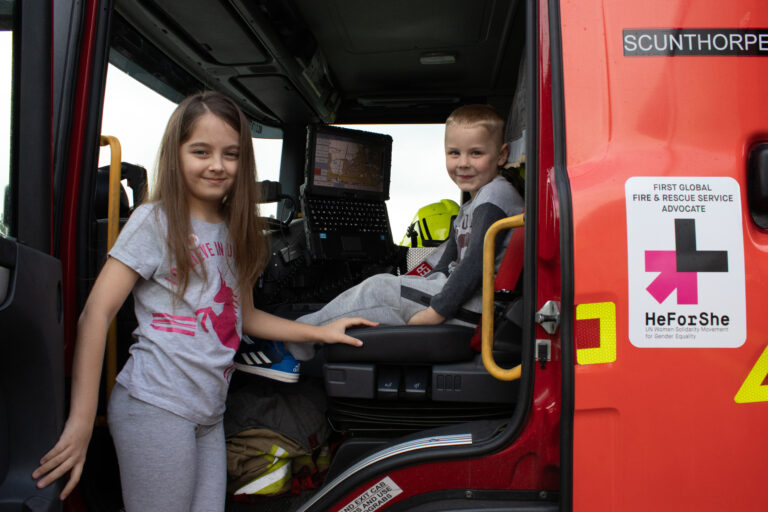 Young grl and boy sat in a Fire Engine