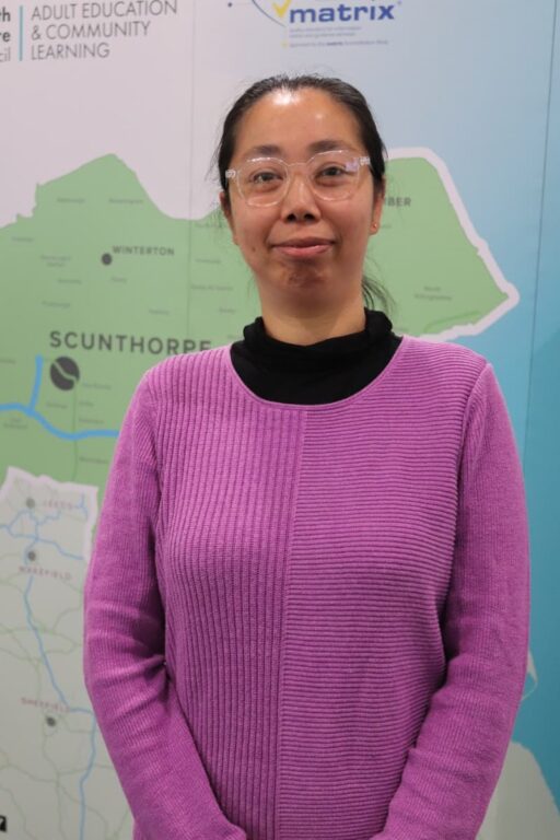Learner dressed in a pink jumper smiling